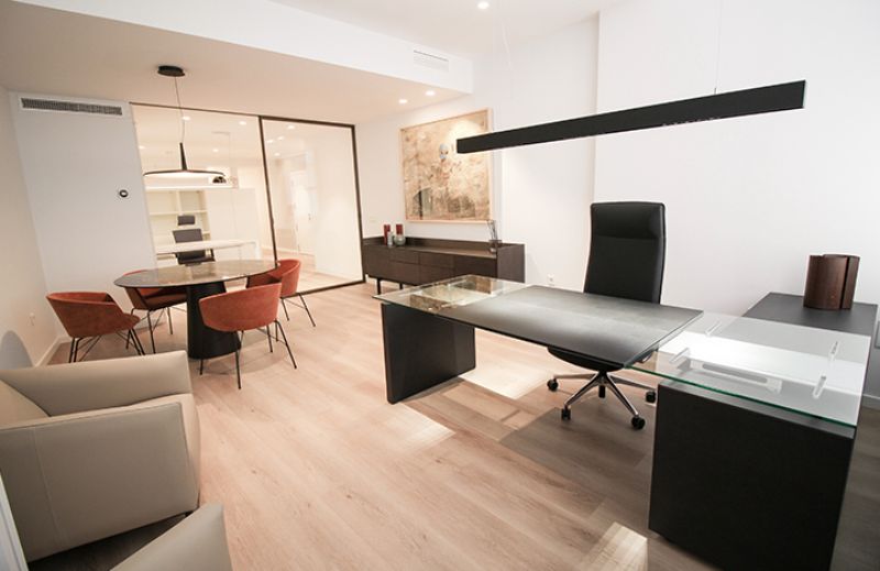 office by Estudio Pas with black desk and orange armchairs