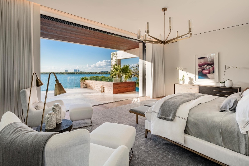 This quiet retreat welcomes you with floor to ceiling windows and seaside views. Wecselman Design made a luxuriously modern living space smoothly transitions to the outdoors thanks to tropical wood and natural organic tone finishes combined with contemporary millwork elements.