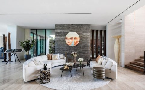 This quiet retreat welcomes you with floor to ceiling windows and seaside views. Wecselman Design made a luxuriously modern living space smoothly transitions to the outdoors thanks to tropical wood and natural organic tone finishes combined with contemporary millwork elements. Traveling through the house, you’ll notice vertical walnut beams gracefully swiveling to divide the formal and informal dining areas, while the kitchen’s cold gray quartzite counterbalances the warm tones of handcrafted walnut cabinetry.